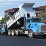 Dump truck and paver installing asphalt