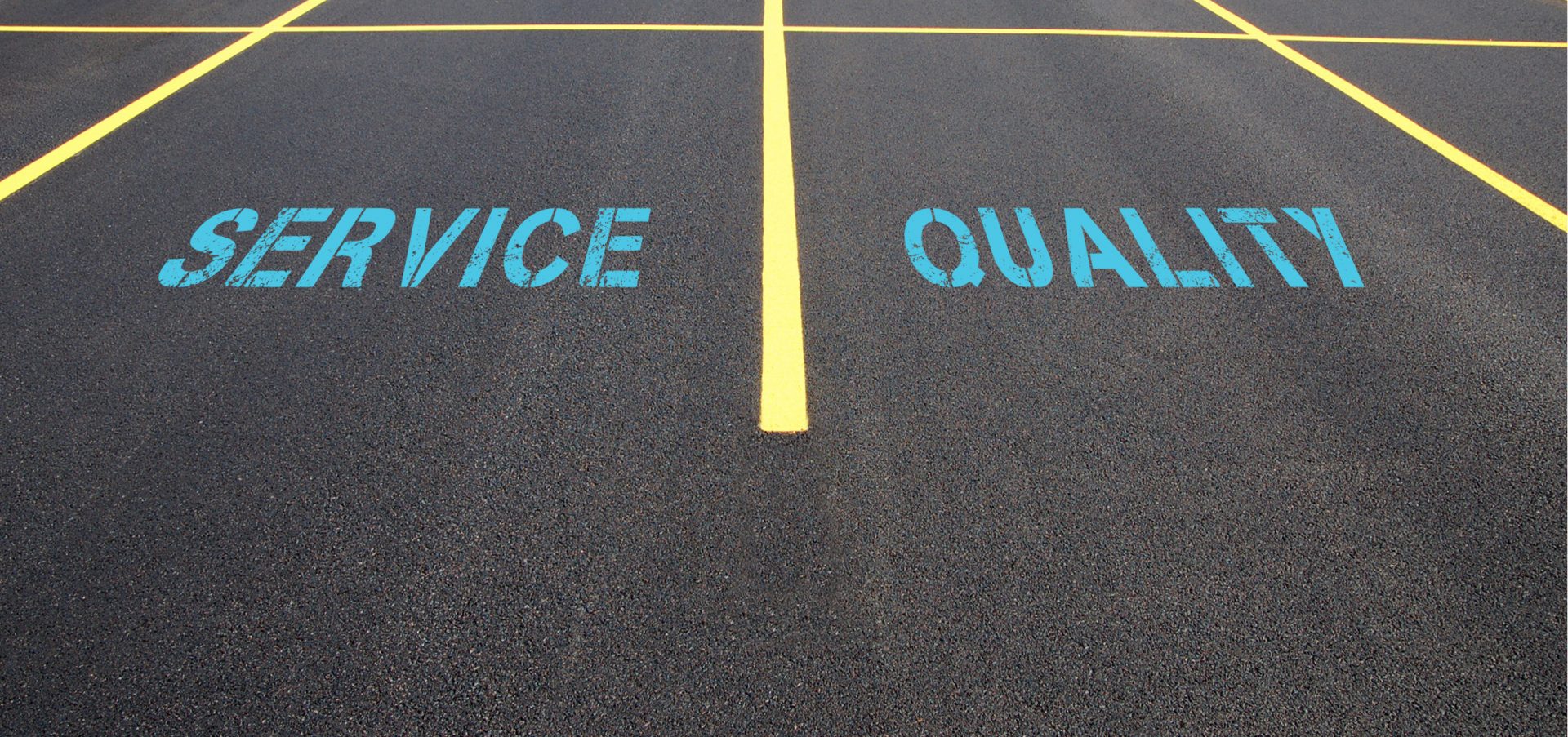 Newly paved parking lot with painted words service and quality