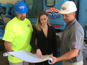 Woman looking at plans with project manager and laborer