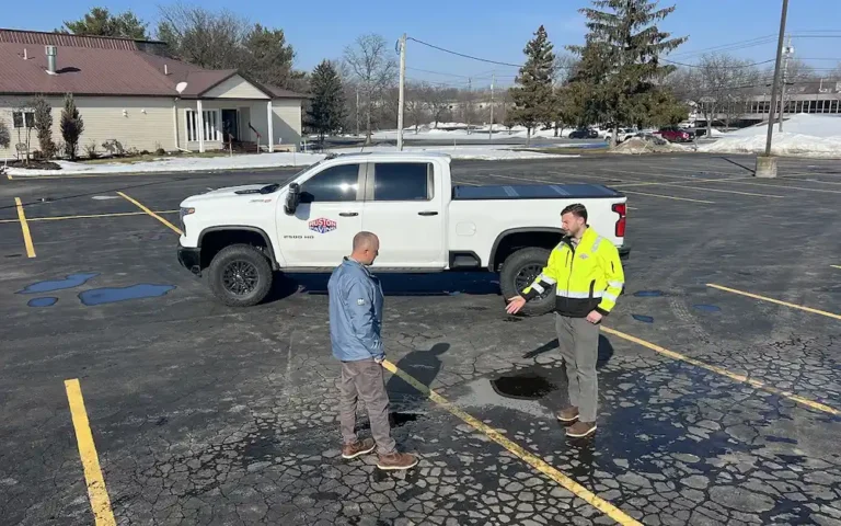 Commercial parking lot repair vs replacement inspection showing cracked pavement and standing water
