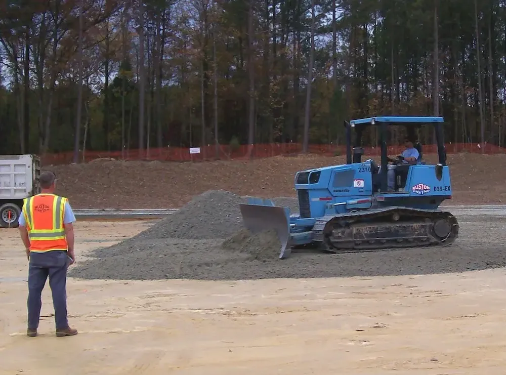 Parking lot replacement base subgrade repair with aggregate material being graded before paving